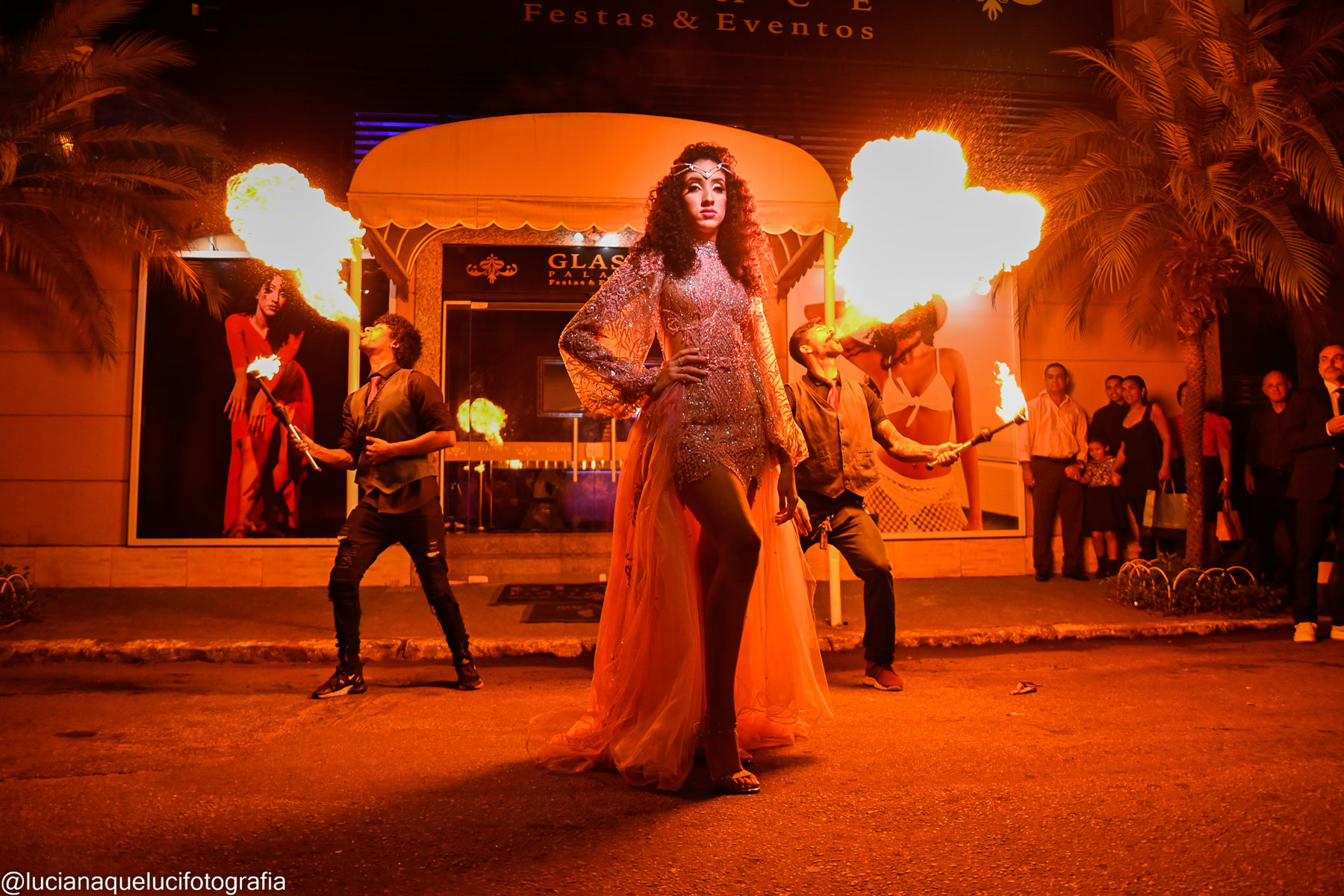 Menina de 15 anos na rua com dois homens ao fundo cuspindo fogo no Glass Palace Festas & Eventos